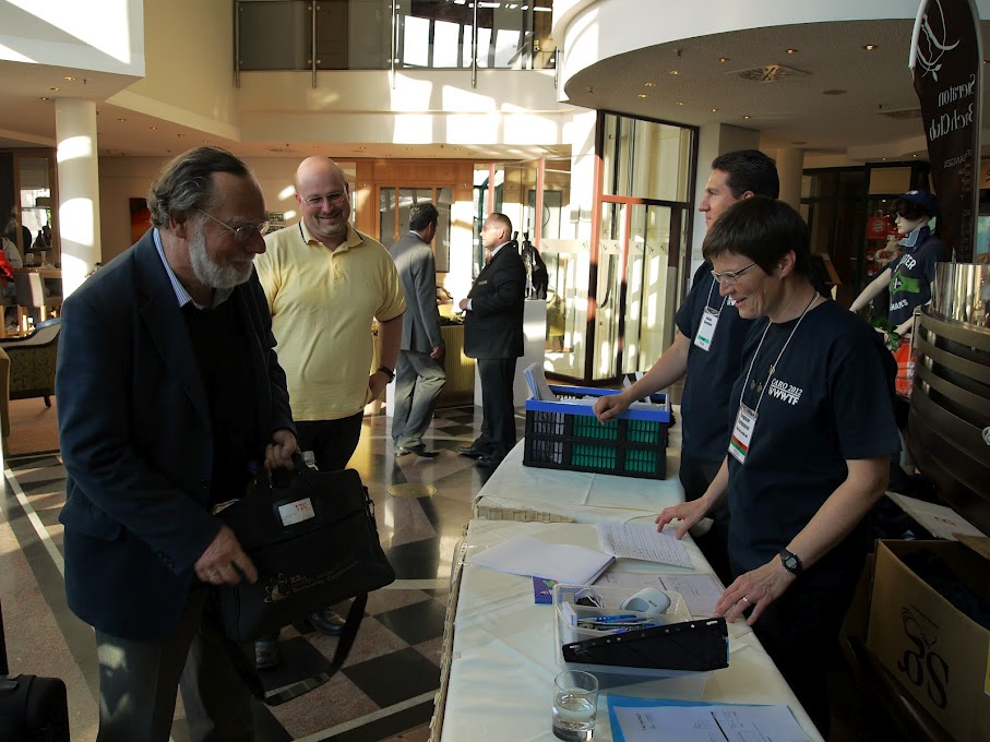 Foto: Begrüßung der CARO 2012 Teilnehmer. Erster in der Wartelinie: Prof. Dr. Klaus Brunnstein, einer der Gründer von CARO