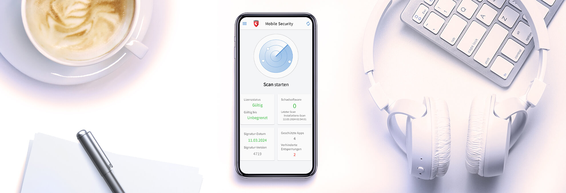 Abgebildet ist ein Schreibtisch von oben. Darauf befinden sich eine Tasse mit Cappucchino, ein Papierstapel mit einem Stift, eine Apple-Tastatur auf der ein Kopfhörer liegt und in der Mitte ein Iphone. Auf diesem sieht man die Softwareoberfläche der G DATA Mobile Security.